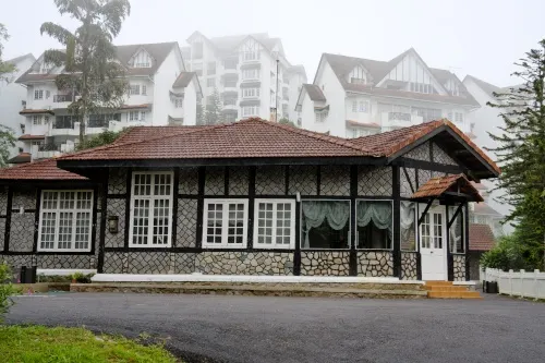 Tudor-style stone house against misty highland apartment buildings.